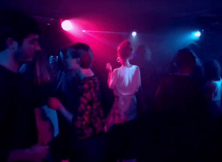 People dancing under coloured lights, scene from the 360° film "Lifeline"