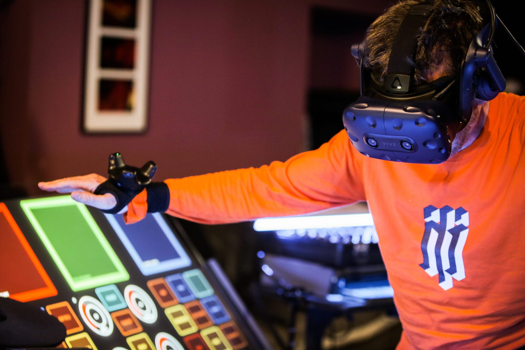 Performer in a VR headset playing a light-up console, Jean-Michel Jarre's virtual concert with VRrOOm
