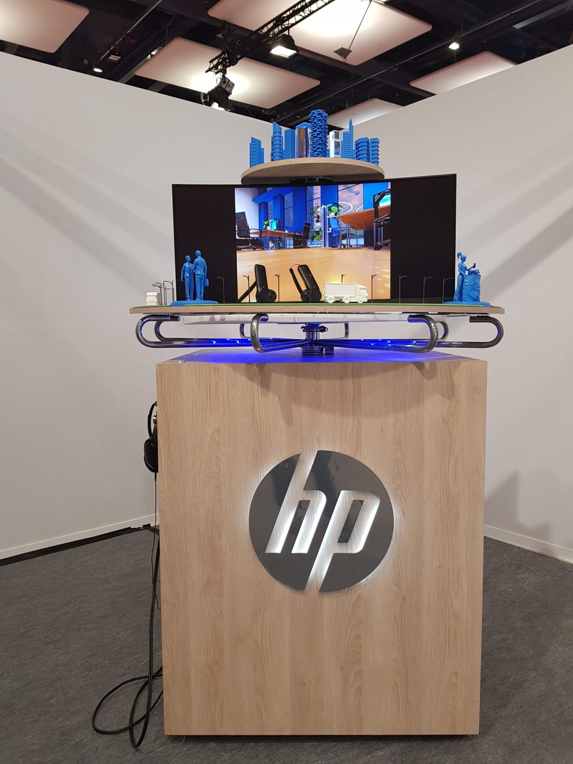 HP phygital model on a wooden stand with a screen and VR headset