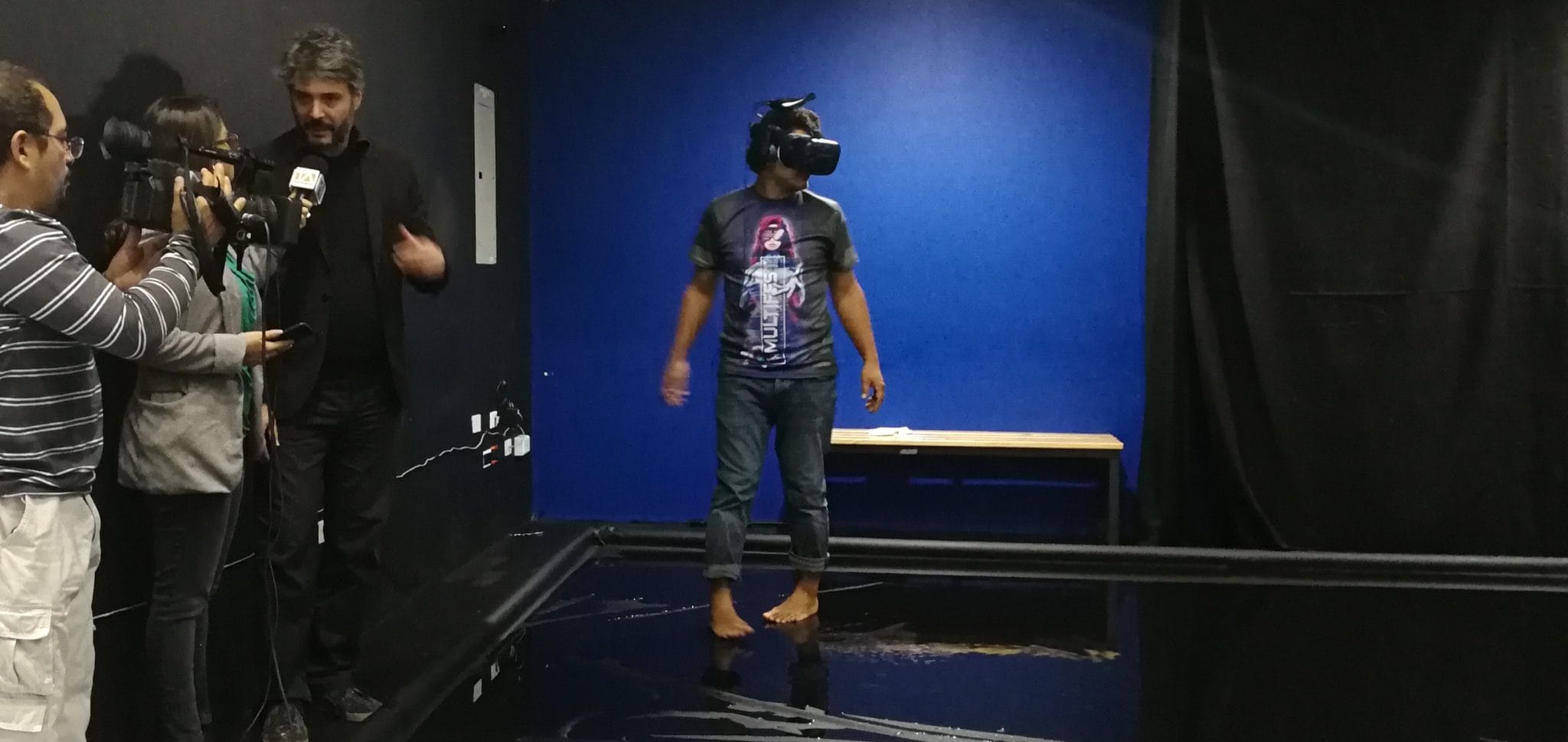 Visitor in a VR headset filmed by a TV crew during an immersive experience at the festival