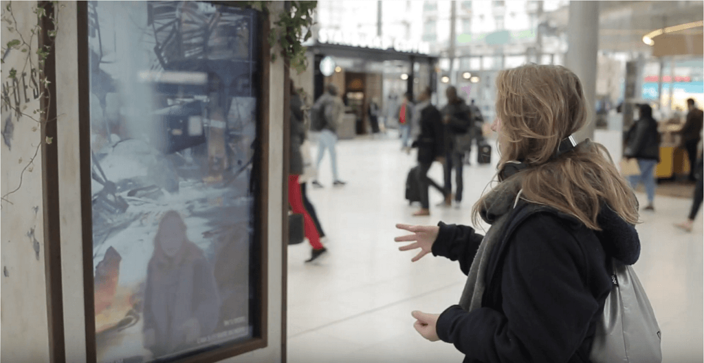 Passer-by at the screen showing a destroyed Gare du Nord, Canal+'s War of the Worlds