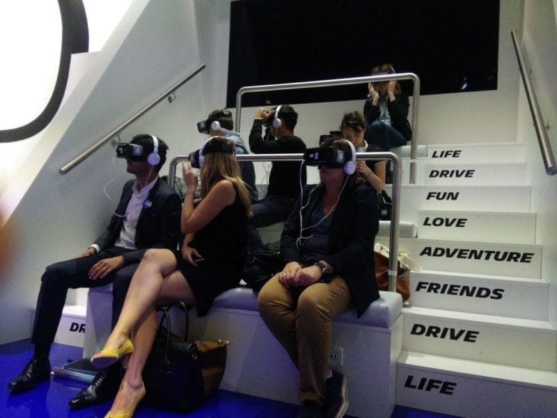 Spectators in VR headsets sitting on the steps of the Michelin Life Experience VR cinema