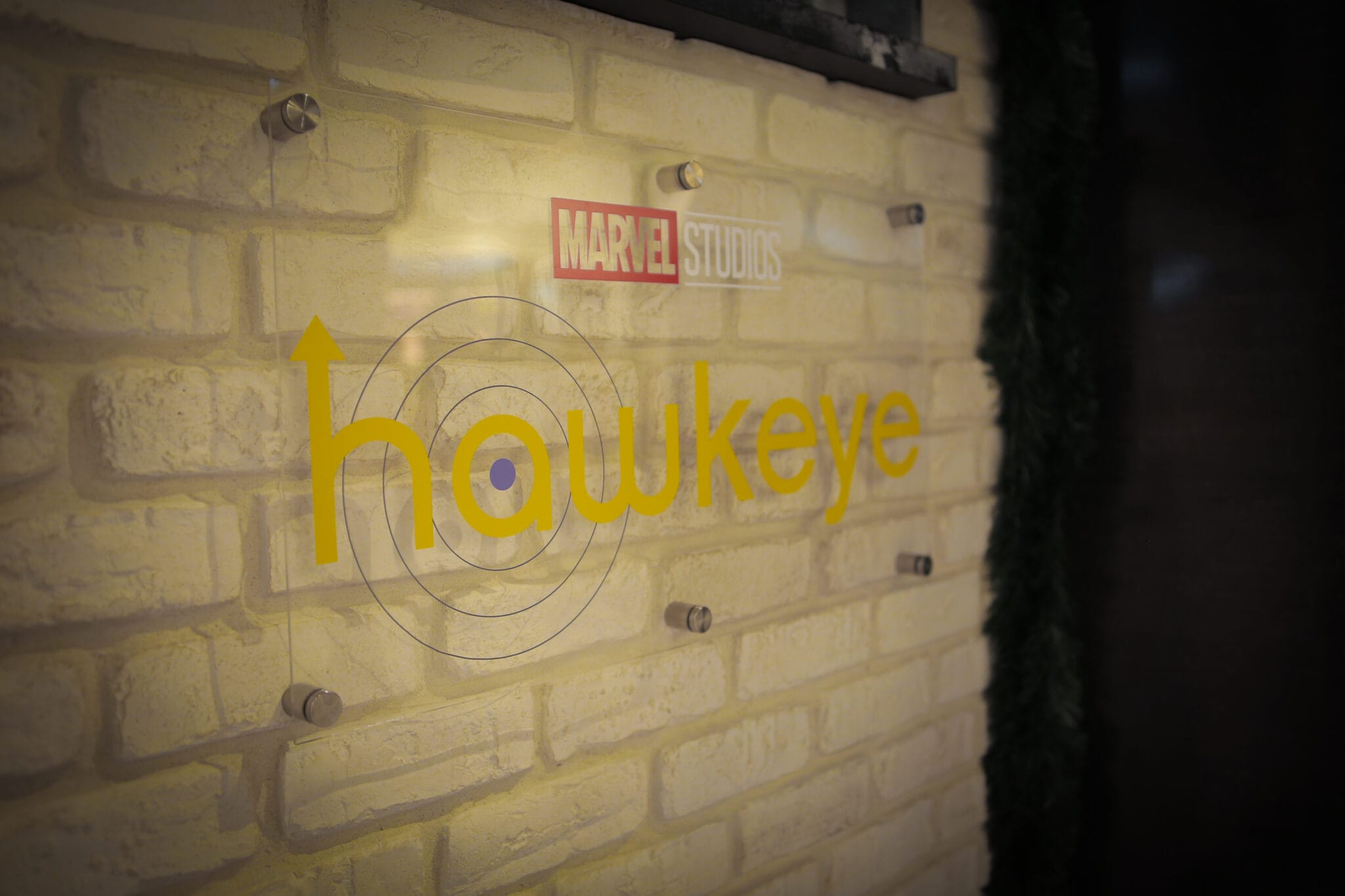 Marvel Studios Hawkeye logo on a brick wall, Disney+ photobooth