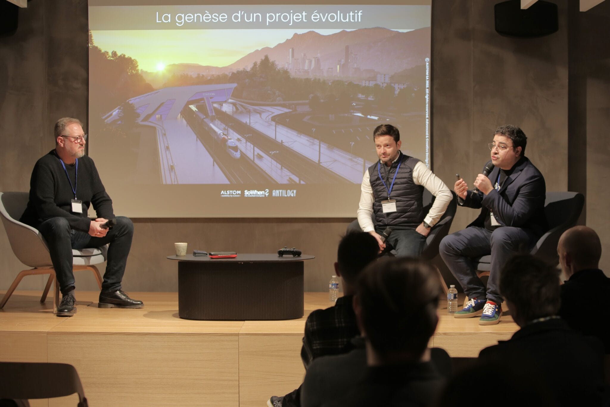 Panel discussion in front of a screen showing the virtual world created for Alstom