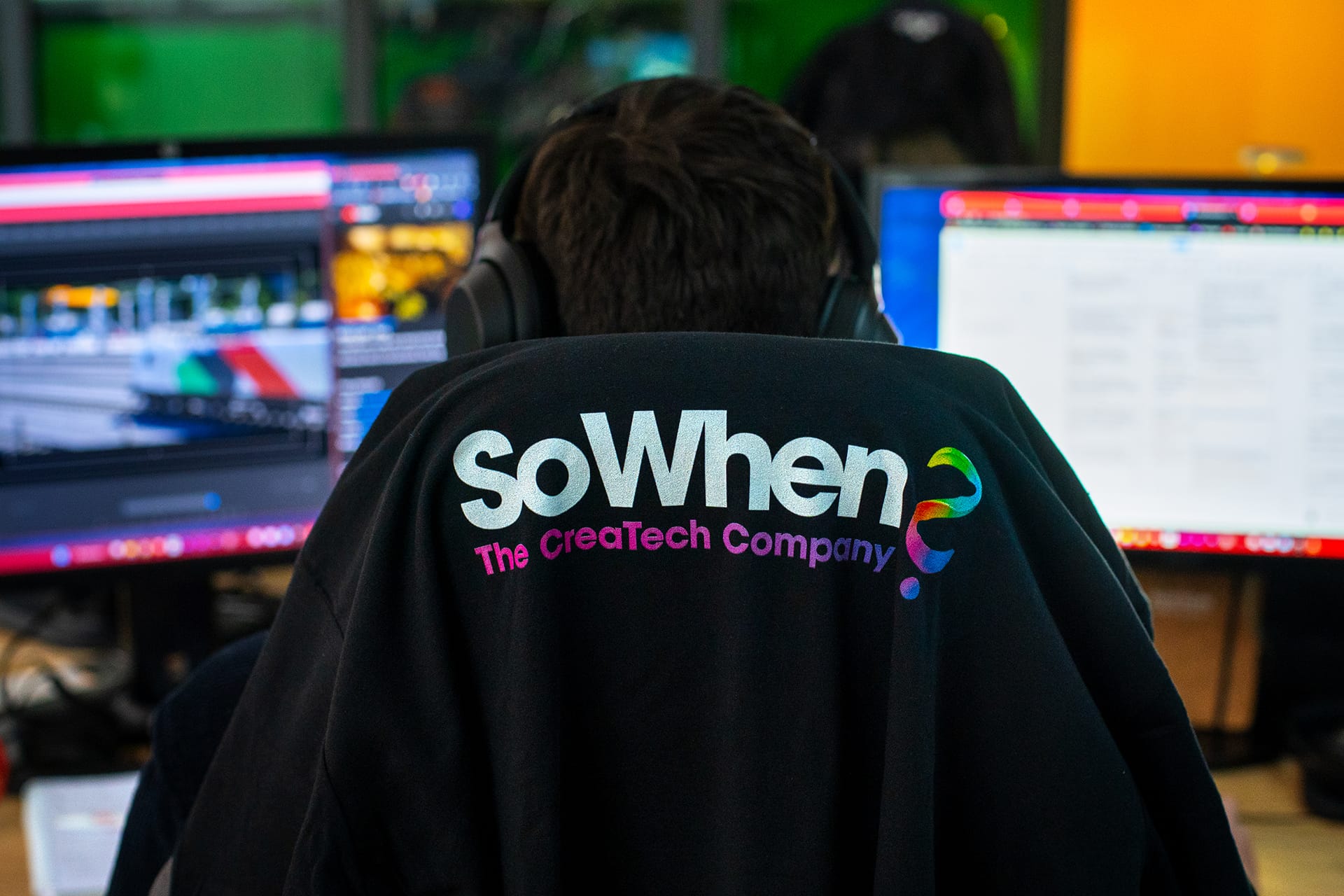 SoWhen? team member seen from behind in front of work screens