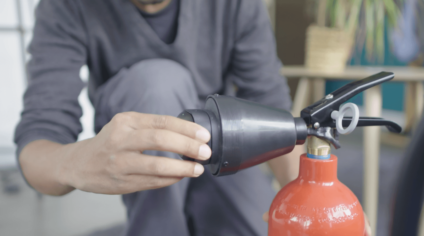 Hand holding a connected extinguisher for the Safety Bus XR fire simulation