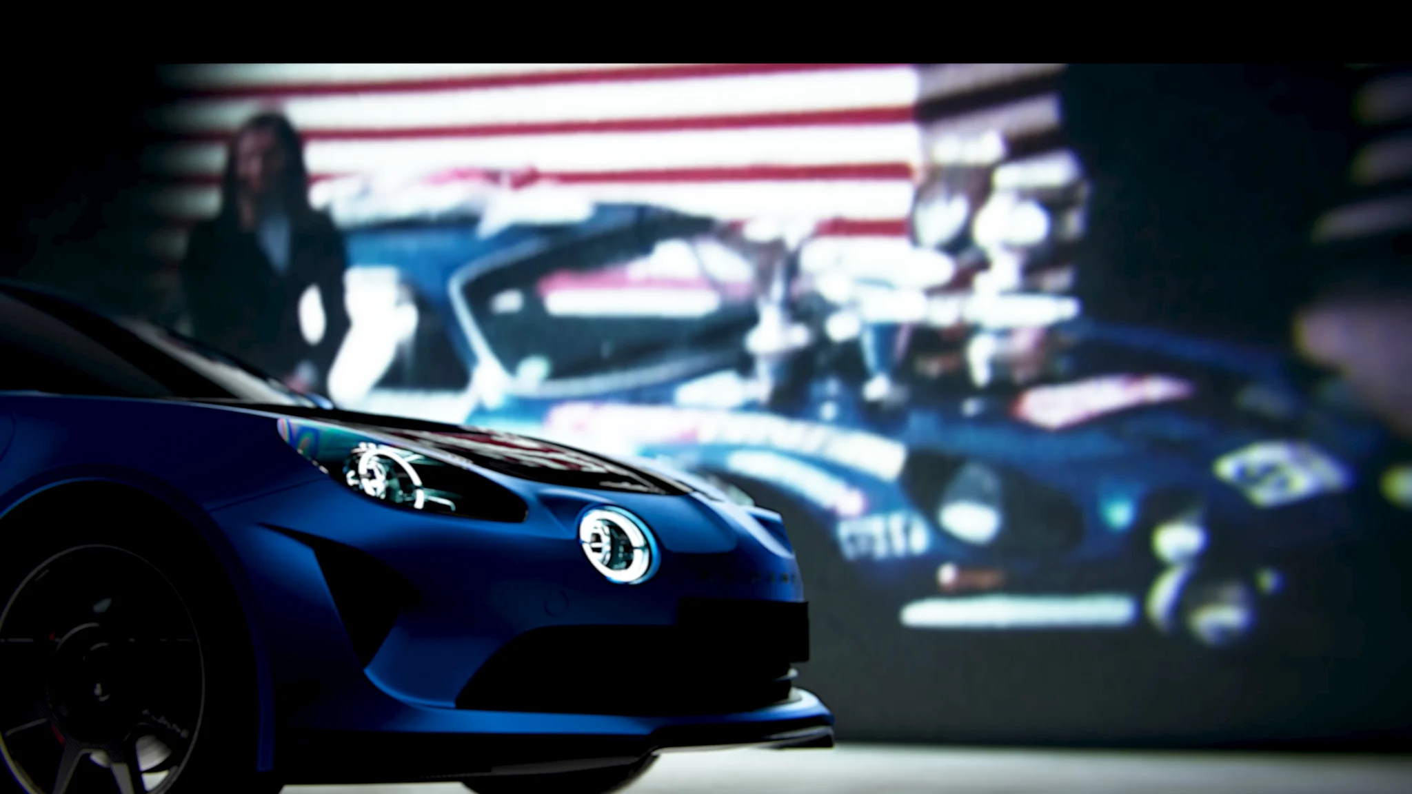 Blue Alpine in front of archive footage of racing Alpines, 3D film