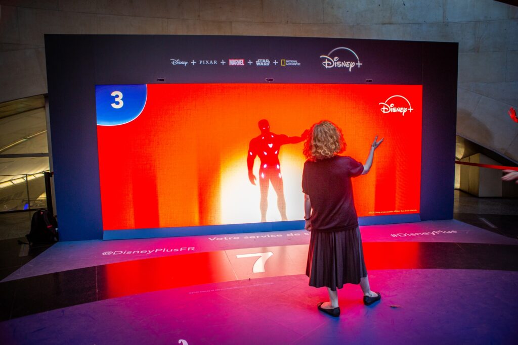 femme qui relève le défi de iron man sur le mur des ombres, dispositif interactif réalisé par SoWhen? pour Disney